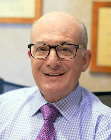 Dr. Allan S. Mohr, DDS, founder of Smile Creations, smiling in the office.