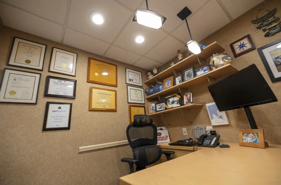 Dr. Ariel's office, with framed diplomas and a large screen.