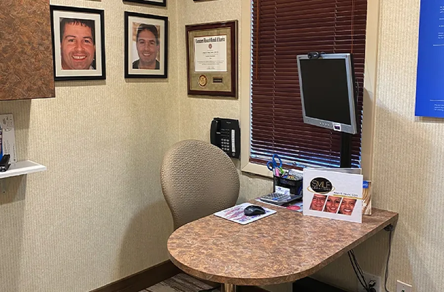A small consultation desk with framed photographs above it.