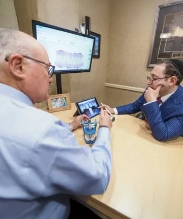 Dr. Mohr and Dr. Ariel reviewing a smile design together on a tablet.