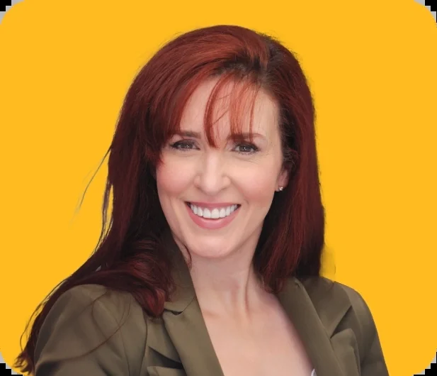 Kim, a Smile Creations patient, smiling against a yellow background.