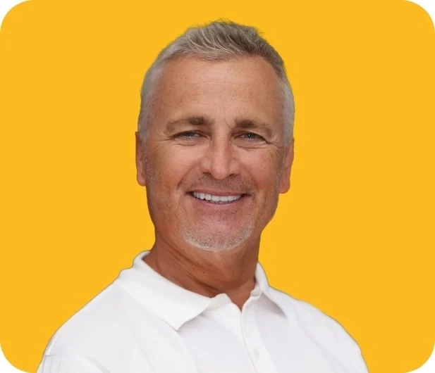 Rick, a Smile Creations patient, smiling against a yellow background.