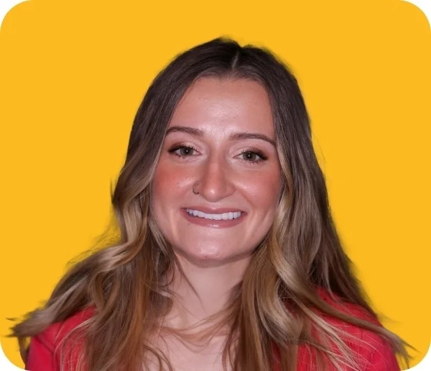 Taylor, a Smile Creations patient, smiling against a yellow background.